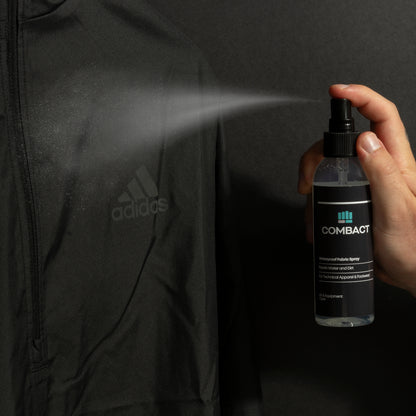 Professional photograph of Combact Waterproof Fabric Spray being sprayed onto running jacket. Used to protect sports kit. Waterproof spray for running jacket. Waterproofing spray for running gear. Waterproof spray for sports equipment. Waterproof spray for running clothes